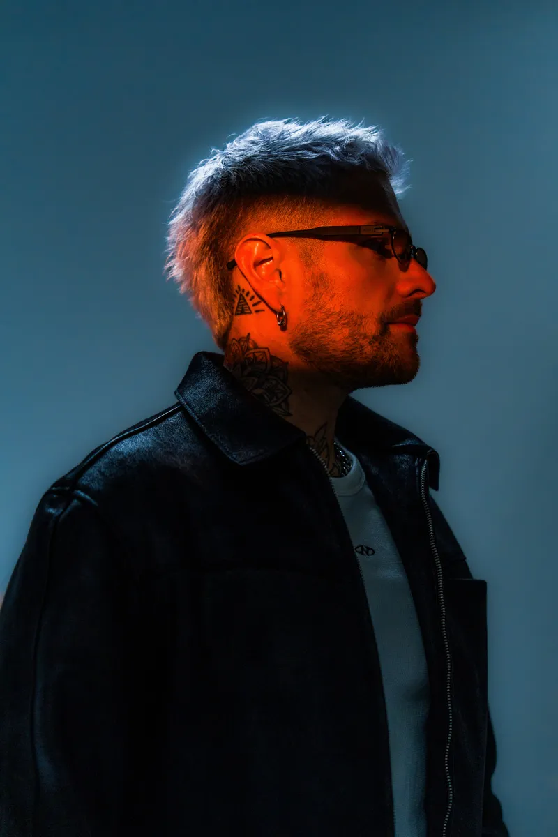 Rafael Cerato in profile under blue and orange studio lighting