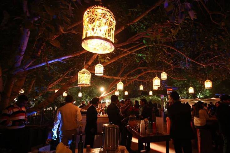 Guests beneath glowing lanterns at Q’la