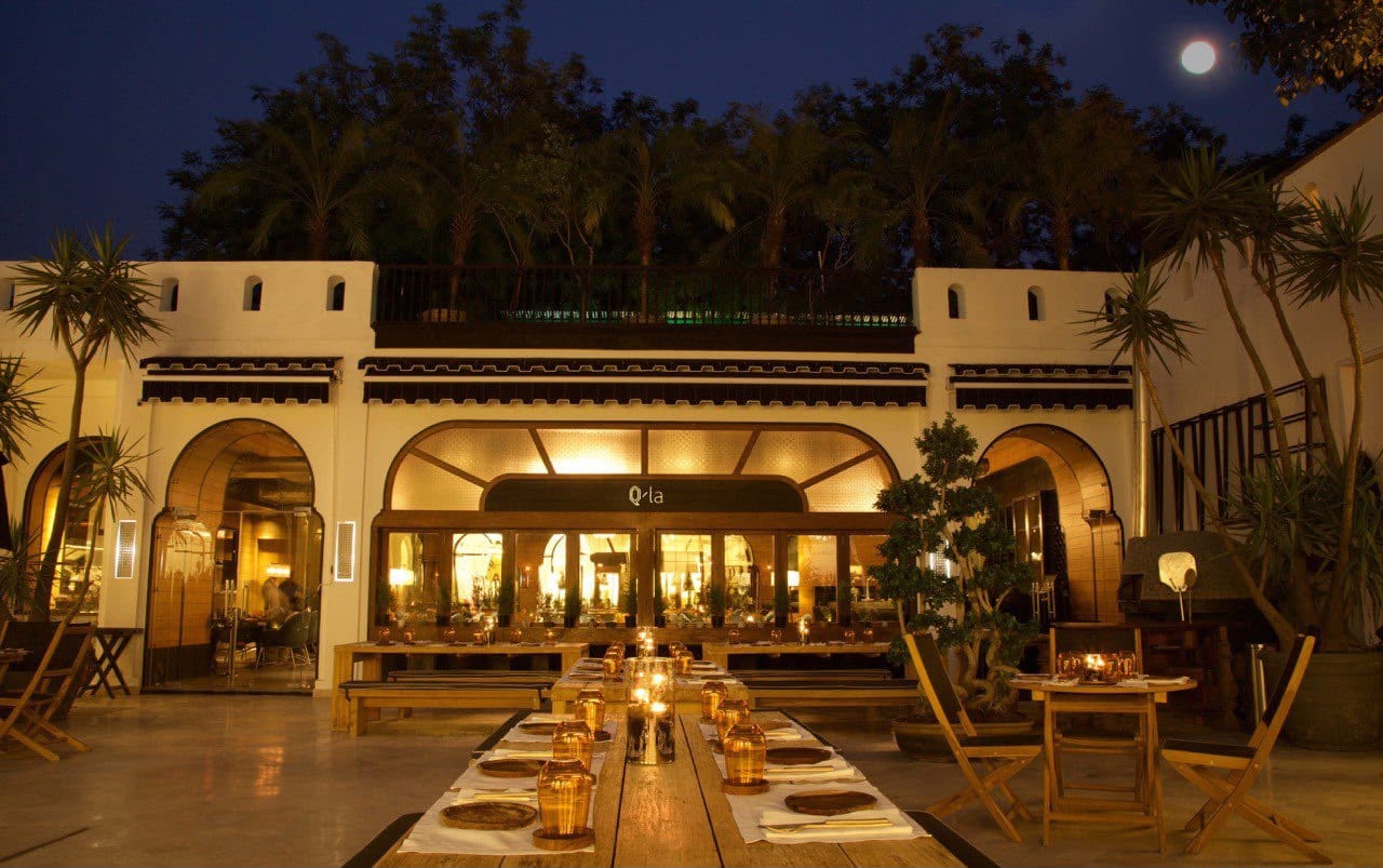 Q’la’s warmly lit facade and outdoor seating